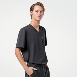 Image of With one hand in his pocket, the male model stands in a Deep Gray scrub set, giving a sleek and professional appearance.