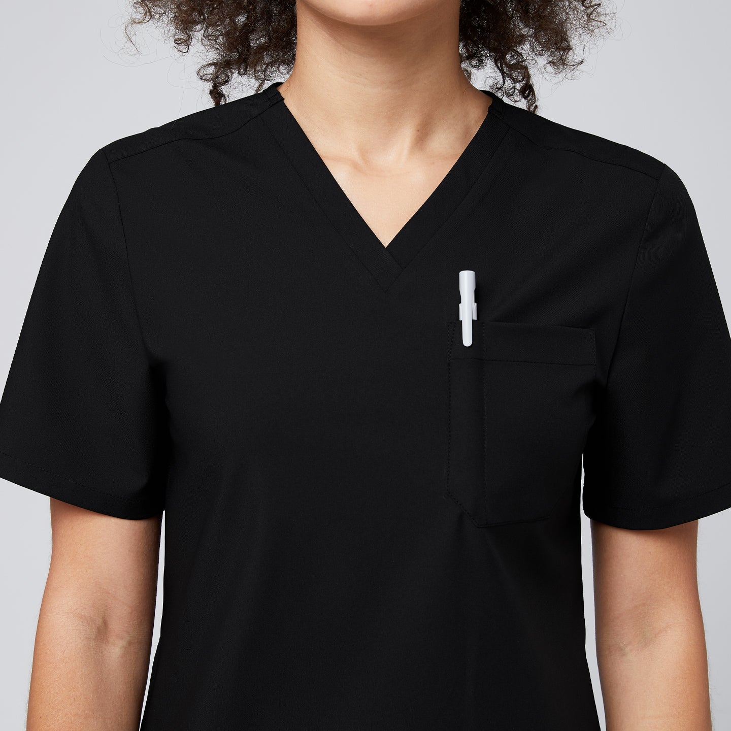 Image of Black V-neck scrub top with a chest pocket holding a white pen,Eco Black