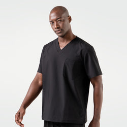 Image of A smiling male model dressed in an Eco Black 3 Pocket scrub top, standing in a relaxed pose.