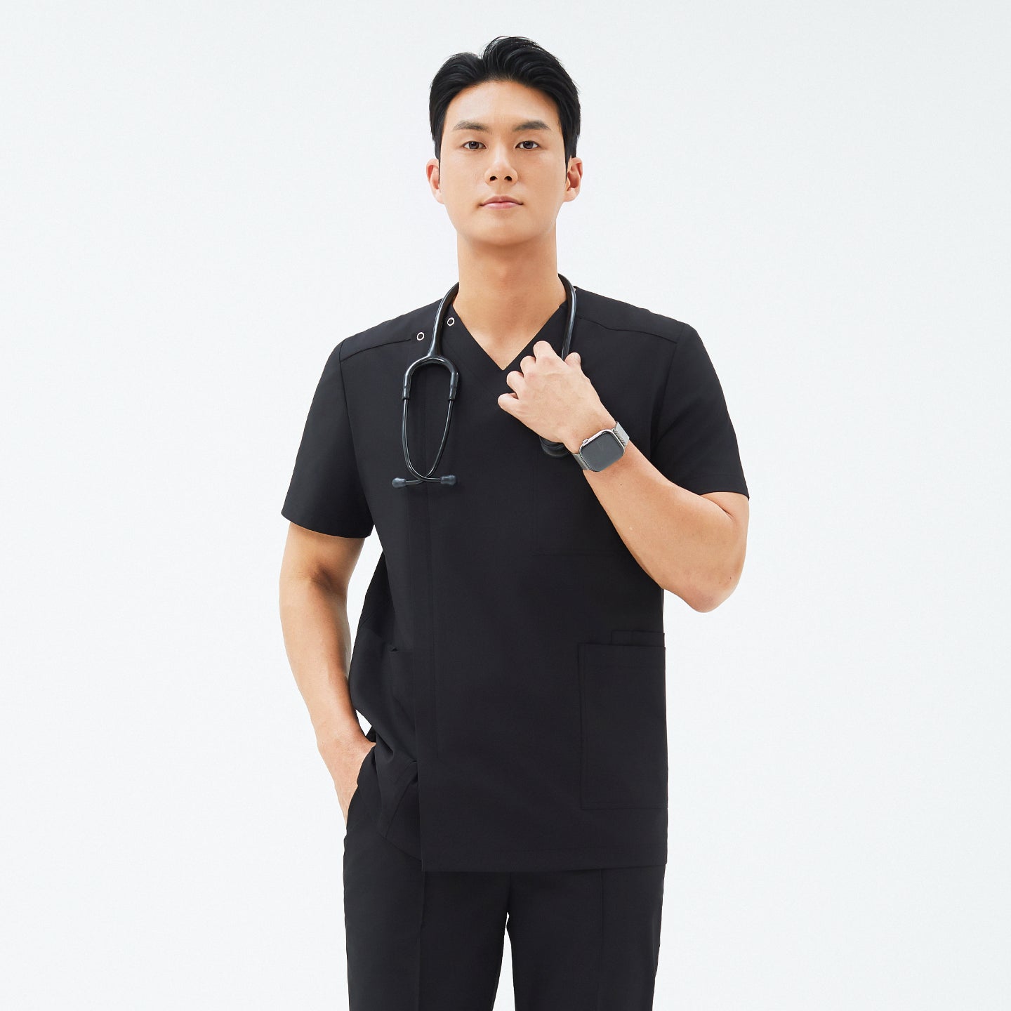 Model wearing TUL DS-184 Eco Black scrub top, highlighting the snap closure near the shoulder, front zipper detail, and tailored fit.