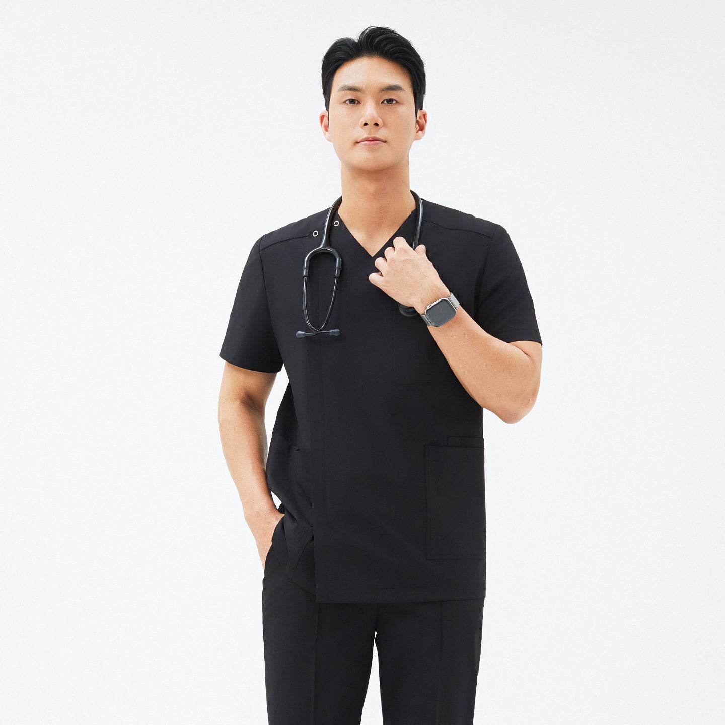 Image of Model wearing TUL DS-184 Eco Black scrub top, highlighting the snap closure near the shoulder, front zipper detail, and tailored fit.