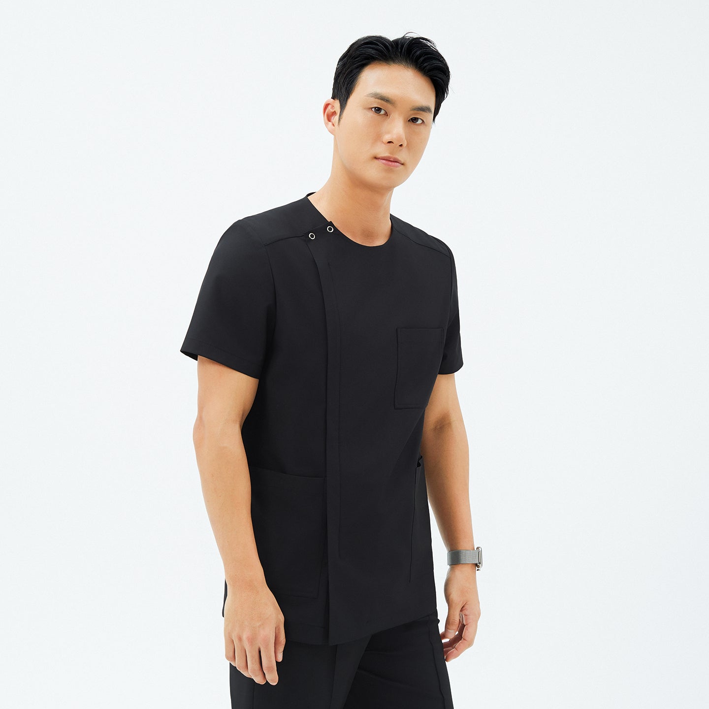 Image of Model wearing TUL DS-187 Men's Round Snap Zipper Scrub Top in Eco Black, featuring a snap collar detail and a sleek front zipper.