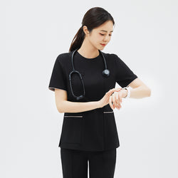 Image of Model checking her watch while wearing TUL OS-206 Women's Edge Stripe Scrub Top in Eco Black, demonstrating comfort and mobility.