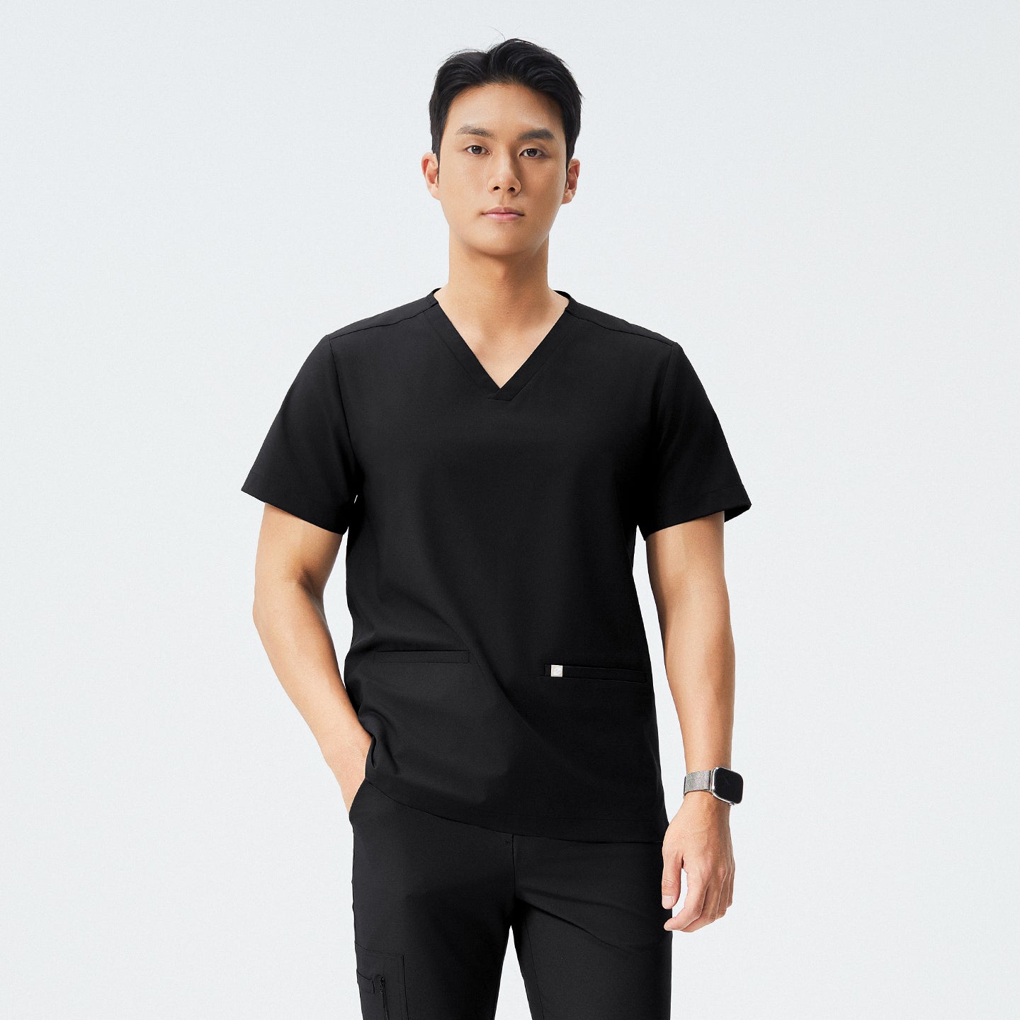 Image of Man wearing black scrubs with a V-neck and double pockets, standing with a neutral expression,Eco Black