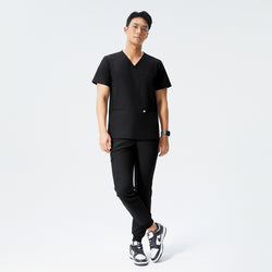 Image of Man wearing eco black scrubs with a V-neck top and jogger-style pants, paired with black sneakers,Eco Black