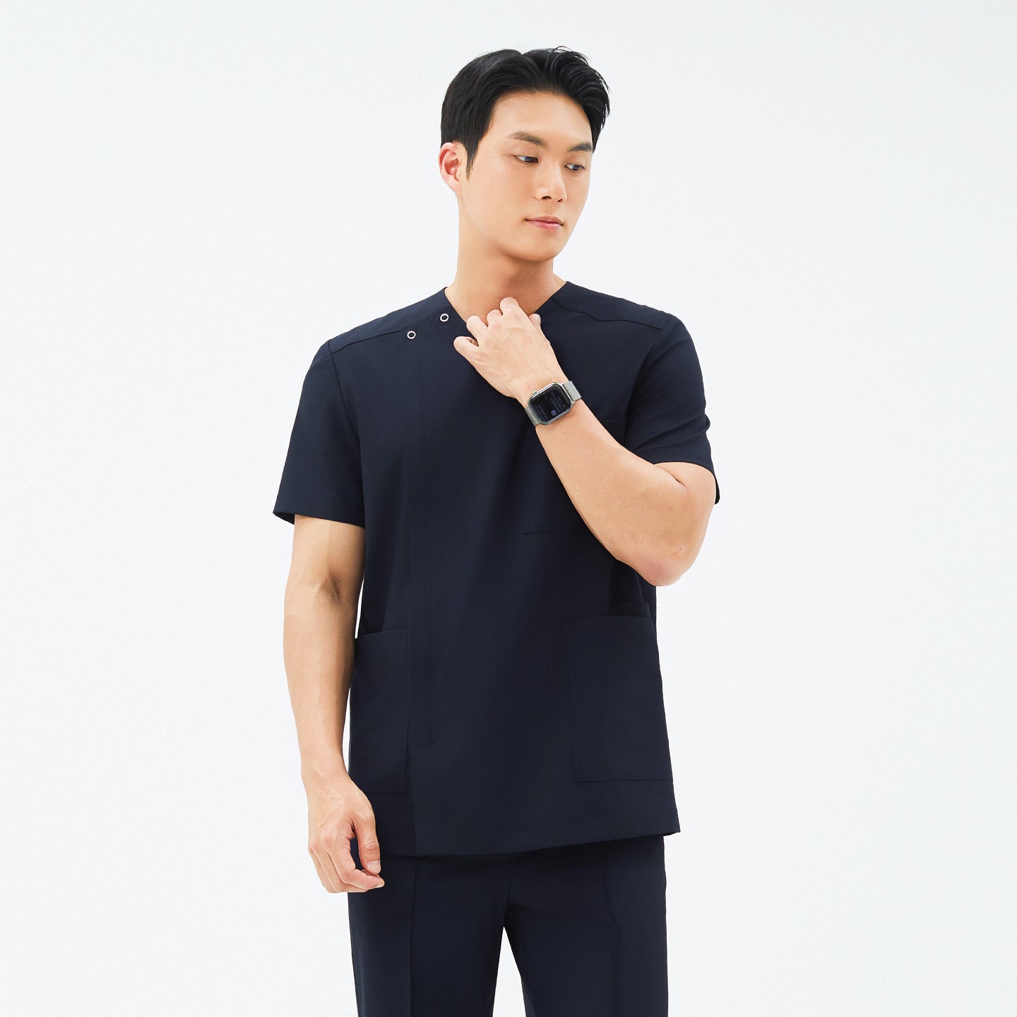 Image of Model wearing TUL DS-185 Men's V-Snap Zipper Scrub Top in Eco Navy, showing snap closures near the shoulder and short sleeves.