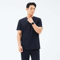 Image of Model wearing TUL DS-185 Men's V-Snap Zipper Scrub Top in Eco Navy, showing snap closures near the shoulder and short sleeves.