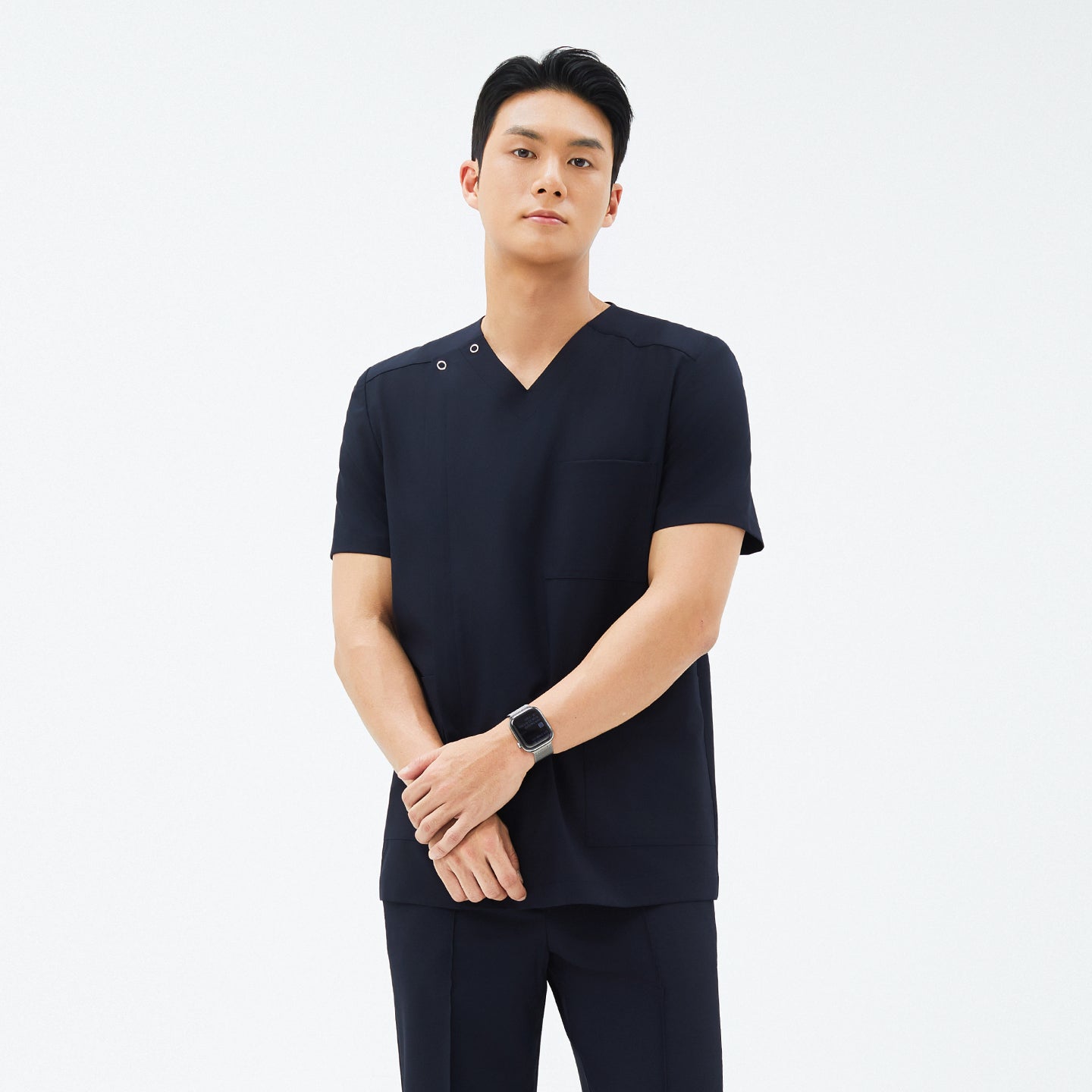Image of Model wearing TUL DS-185 Men's Eco Navy scrub top, emphasizing the V-neck design, front pockets, and a comfortable fit.