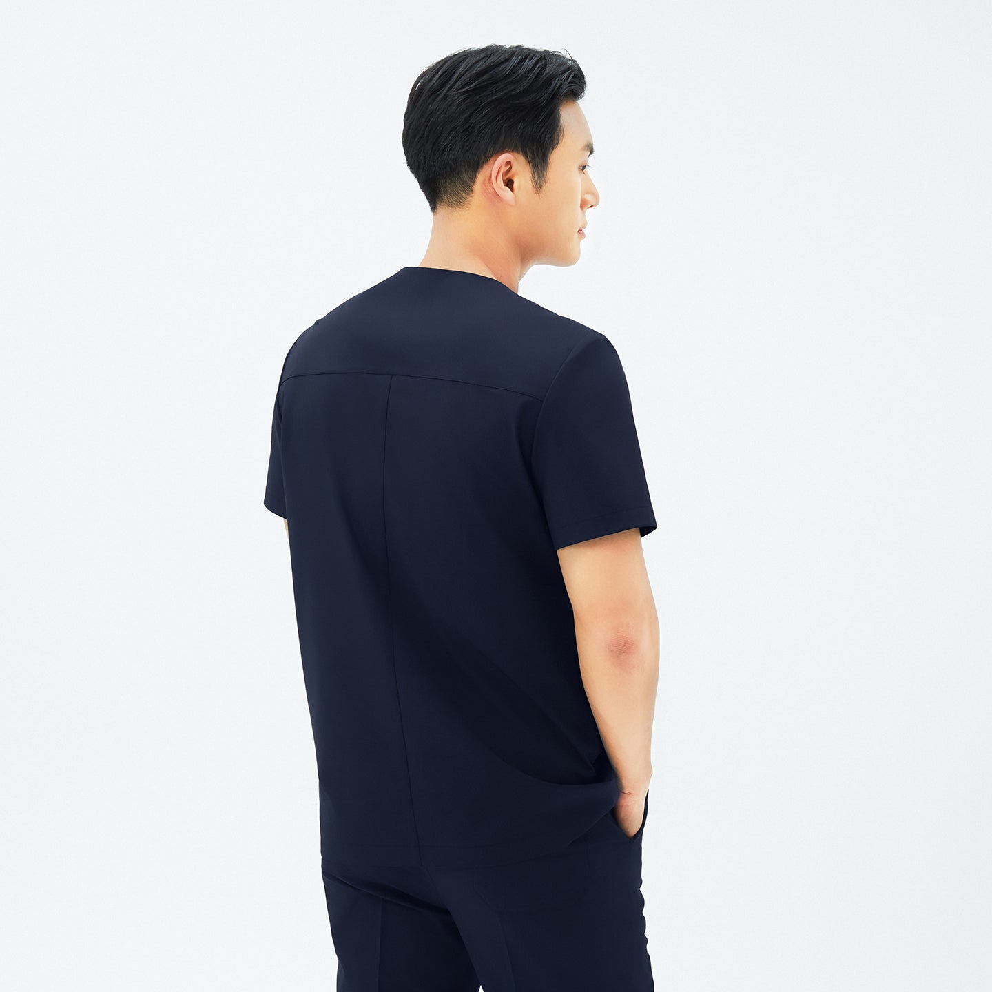 Back view of TUL DS-188 Men's Round Snap Zipper Scrub Top in Eco Navy, emphasizing structured seams and a comfortable silhouette.