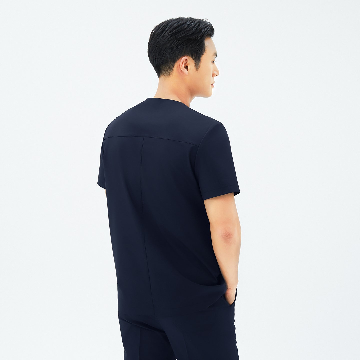 Image of Back view of TUL DS-188 Men's Round Snap Zipper Scrub Top in Eco Navy, emphasizing structured seams and a comfortable silhouette.