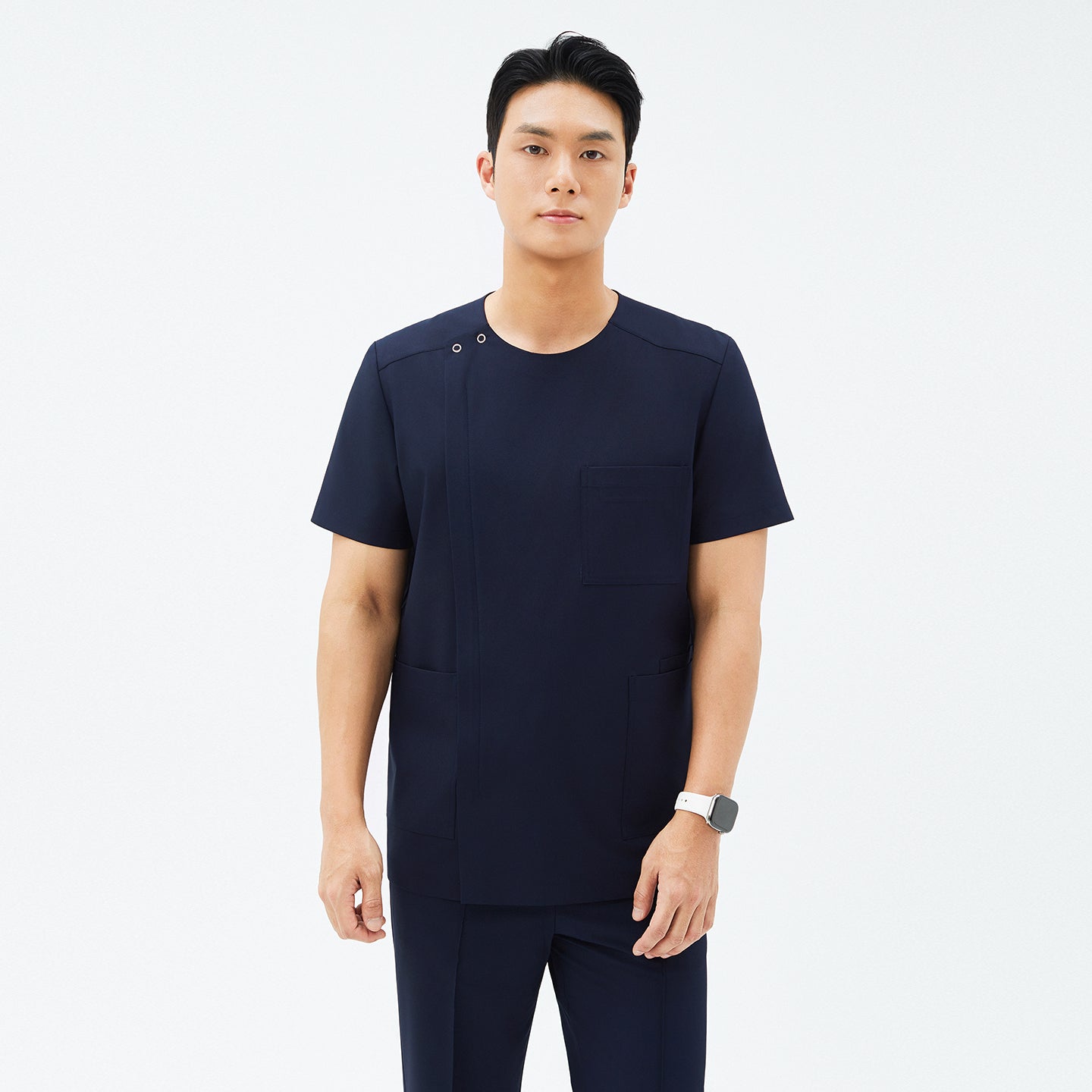 Model wearing TUL DS-188 Men's Eco Navy scrub top, paired with matching pants for a cohesive, professional uniform.