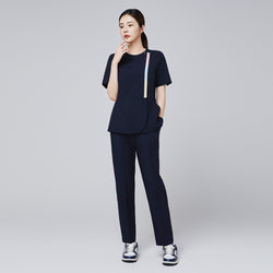 Image of Eco navy scrub set with short-sleeve top featuring colorful stripe detail and matching banding pants, paired with navy and white sneakers,Eco Navy