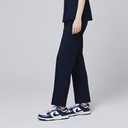 Image of Side view of eco navy banding scrub pants with a relaxed fit, paired with stylish navy and white sneakers,Eco Navy