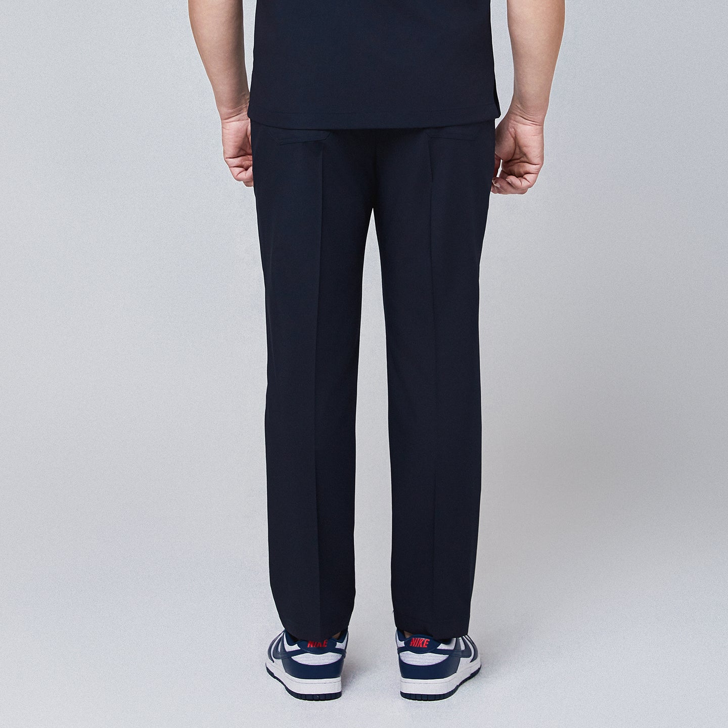 Back view of navy blue M-line banding scrub pants paired with white and blue Nike sneakers,Eco Navy