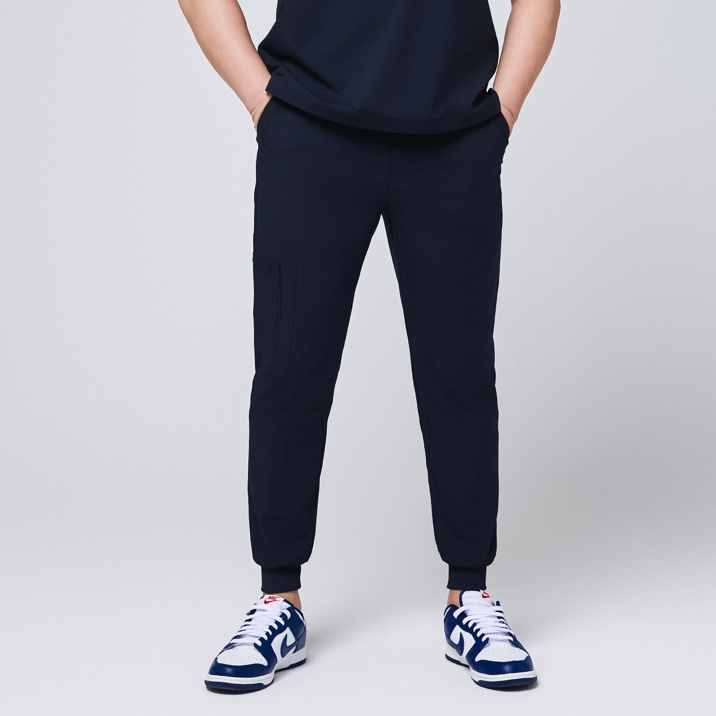 Image of Front view of navy jogger scrub pants with a zipper pocket and elastic cuffs,Eco Navy