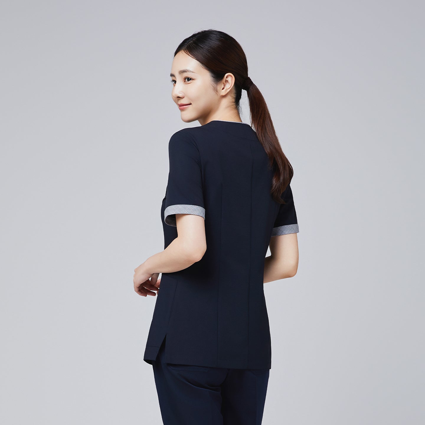 Image of Back view of navy scrub top with short sleeves and subtle detailing, showcasing a professional and tailored fit,Eco Navy