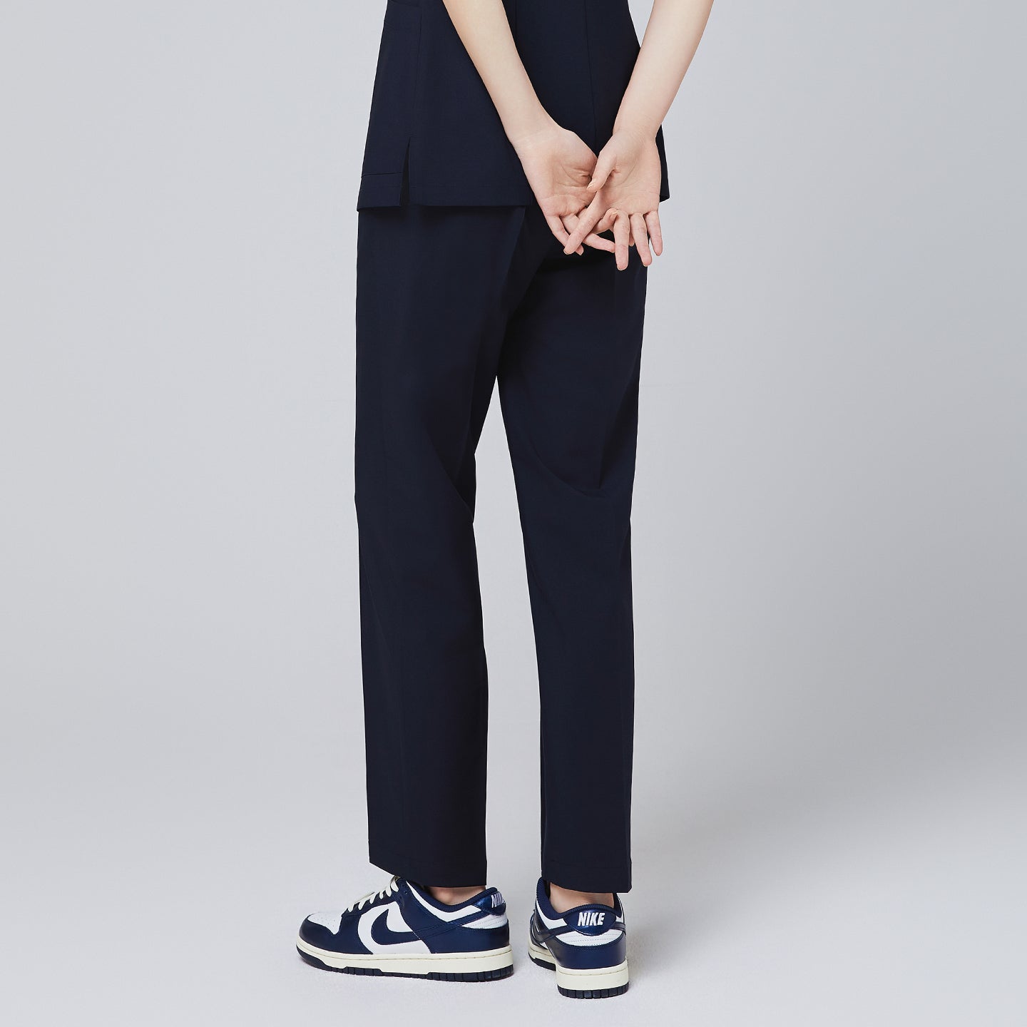 Image of Back angle of TUL Women's Premium Banding Pants in Eco Navy, emphasizing a structured waistband and relaxed, professional silhouette.