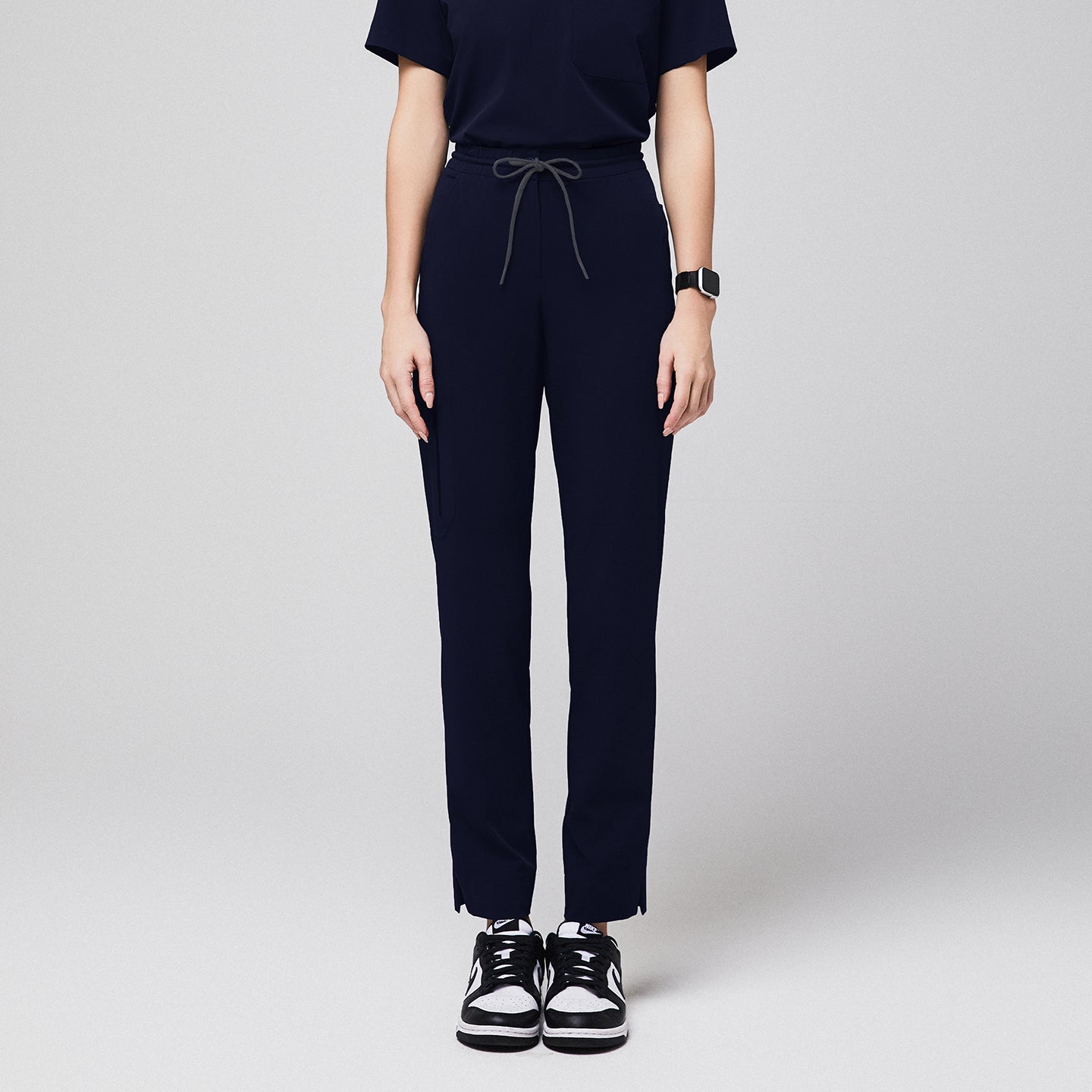 Front view of Zenir Women's Zipper Pocket Split Hem Scrub Pants in Eco Navy on a model, highlighting the clean, straight-leg cut, functional zipper pockets, and the dynamic split hem design.