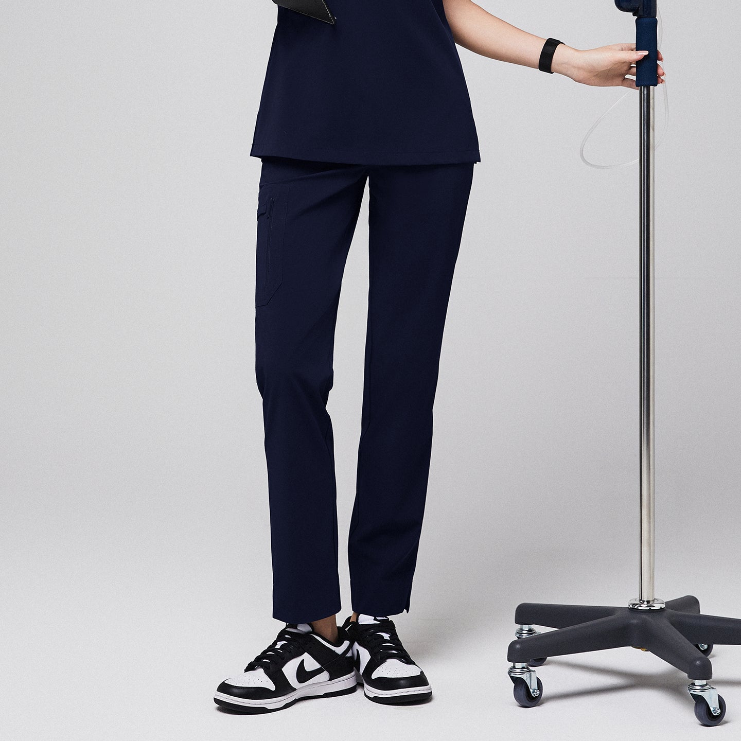 Image of In eco navy, zipper-pocket split-hem scrub pants Zenir with straight-leg fit and thigh utility pocket, model shot.