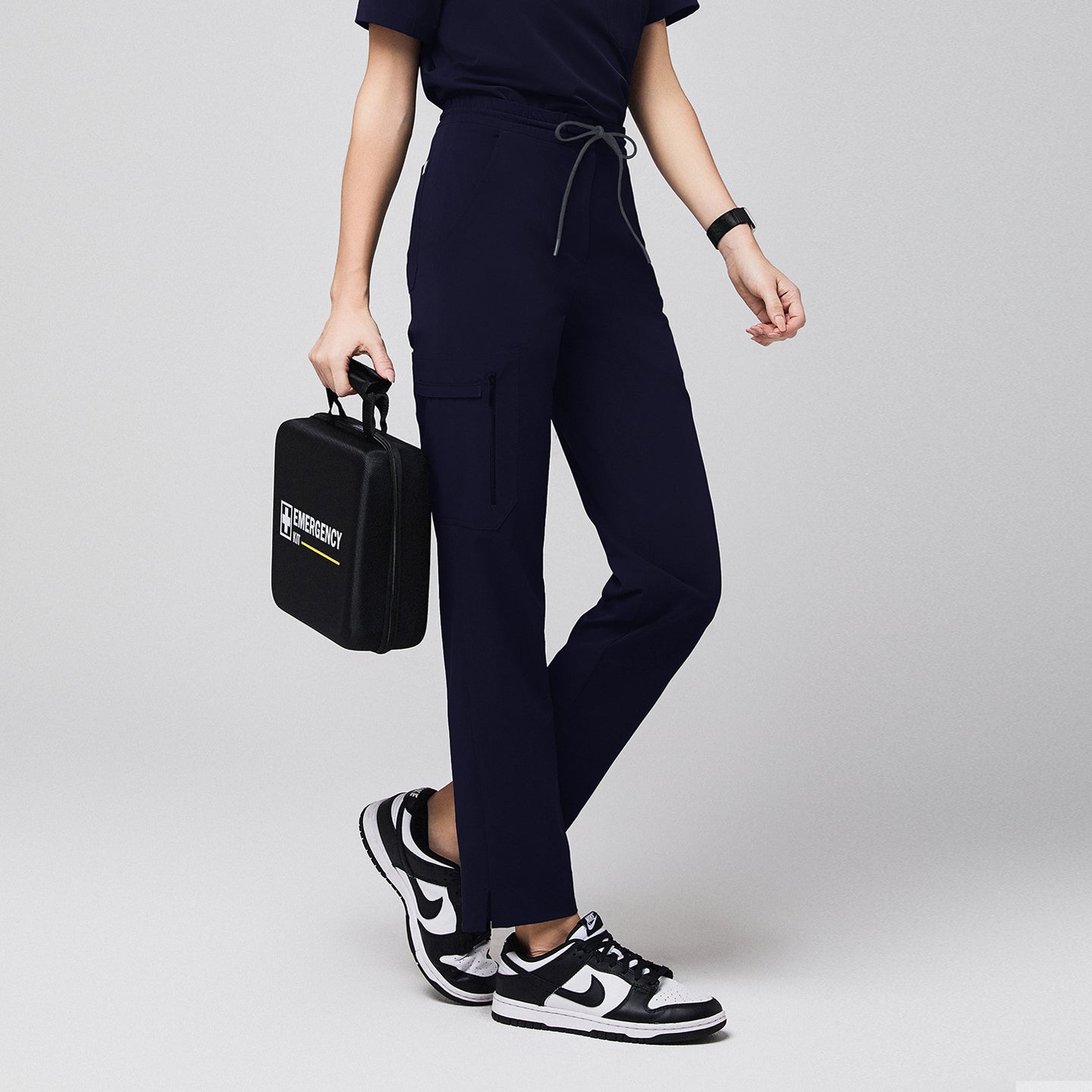 Image of Eco navy zipper-pocket scrub pants Zenir, half-side shot with split-hem cuffs and tie waist.