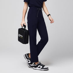 Image of Close-up view highlighting the split hem detail of the Zenir Women's Zipper Pocket Split Hem Scrub Pants in Eco Navy. The photo focuses on the precise cut of the hem and a zipper pocket detail along the hip.