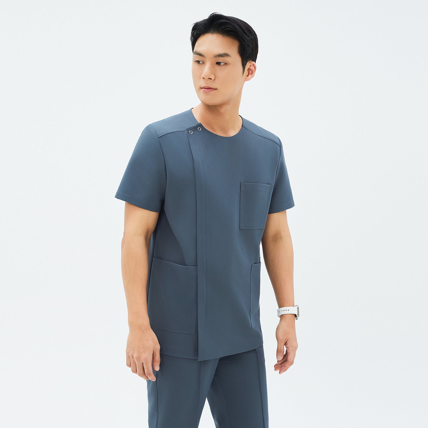Another angle of TUL DS-190 Men's Round Snap Zipper Scrub Top in Haze Gray, featuring short sleeves and a modern, structured design.