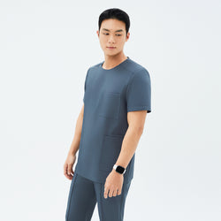 Image of Model wearing TUL DS-190 Haze Gray scrub top, emphasizing the snap closure near the shoulder and overall streamlined silhouette.