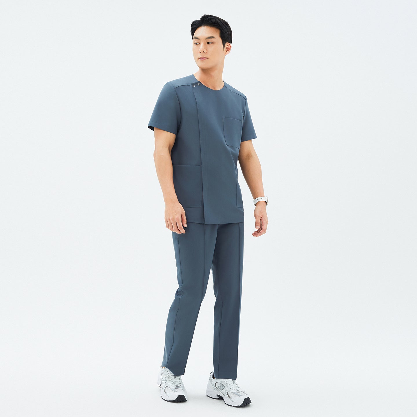 Full outfit featuring TUL DS-190 Men's Round Snap Zipper Scrub Top in Haze Gray, paired with matching pants and sneakers for a professional yet comfortable look.