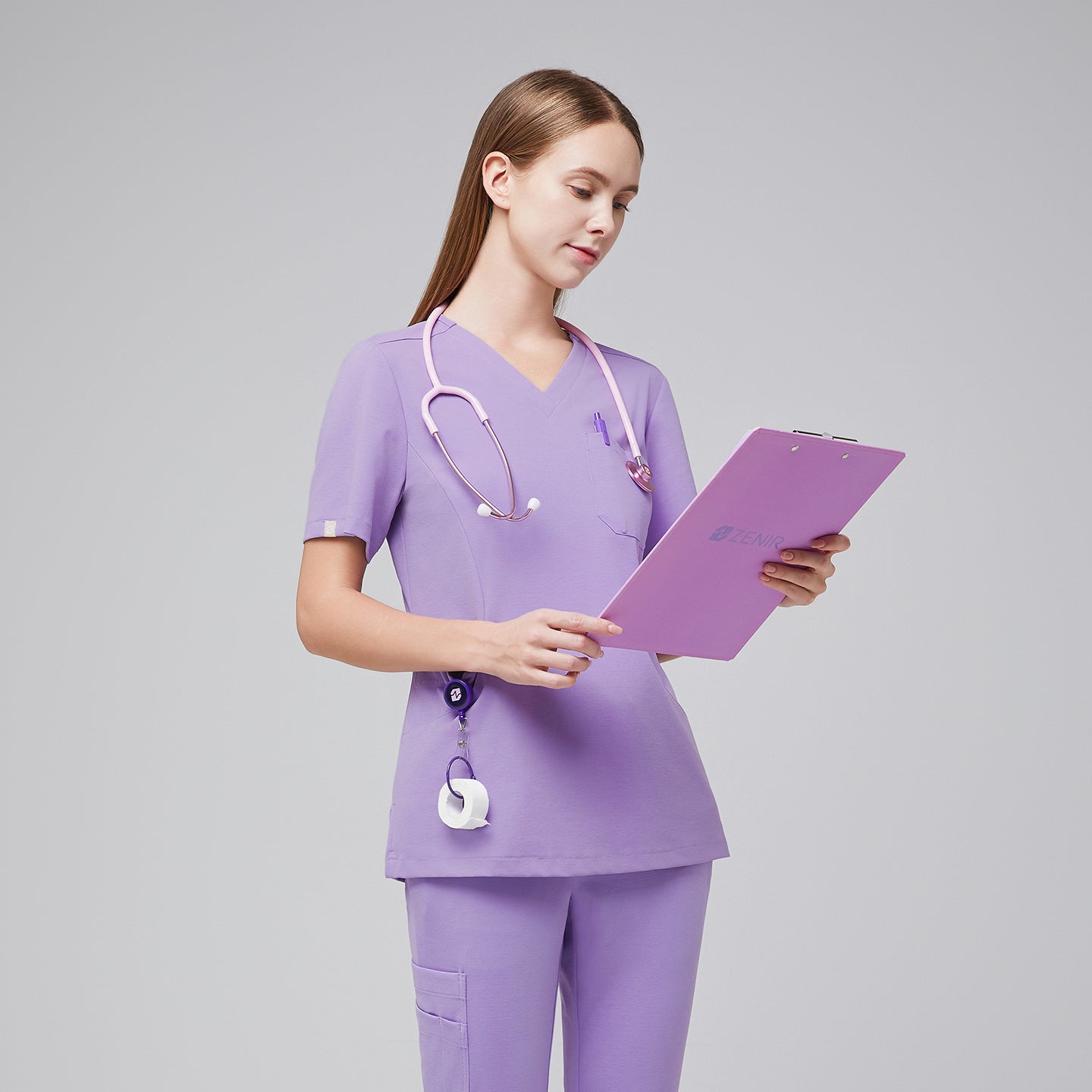 Woman wearing a lavender scrub set, holding a clipboard and walking confidently, highlighting the professional and functional design of the uniform,Lavender