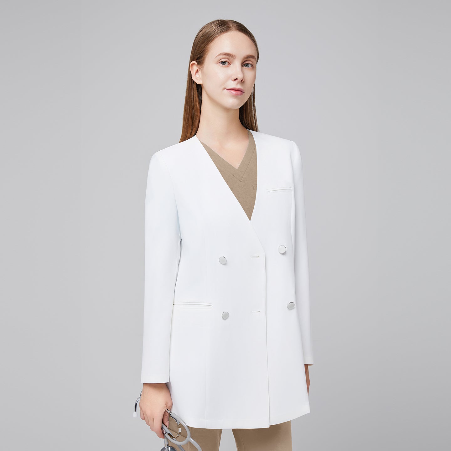 Image of A woman wearing a white long lab coat (LCW-09) over a Sand Beige Pleated Shoulder Scrub Top and Sand Beige Straight Split Hem Scrub Pants, holding a stethoscope,White