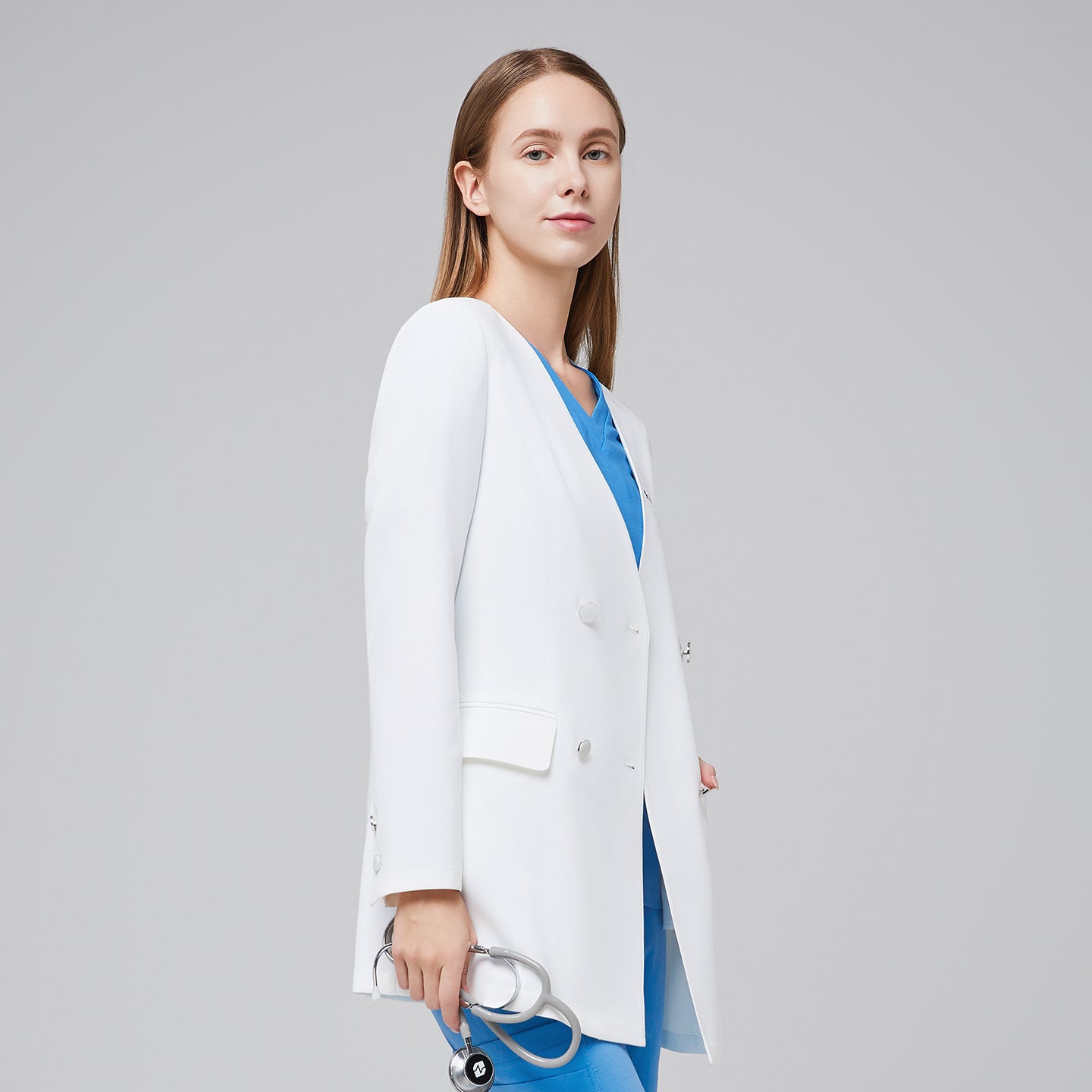 Side view of a woman wearing a white long lab coat (LCW-09) over an Aqua Blue Pleated Shoulder Scrub Top and Aqua Blue Straight Split Hem Scrub Pants, holding a stethoscope,White