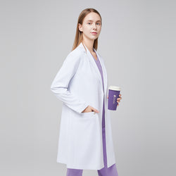 Image of A woman wearing a white long lab coat (LCW-10) over a Lavender Soft Stretch Scrub Top and Lavender Straight Split Hem Scrub Pants, holding a coffee cup,White