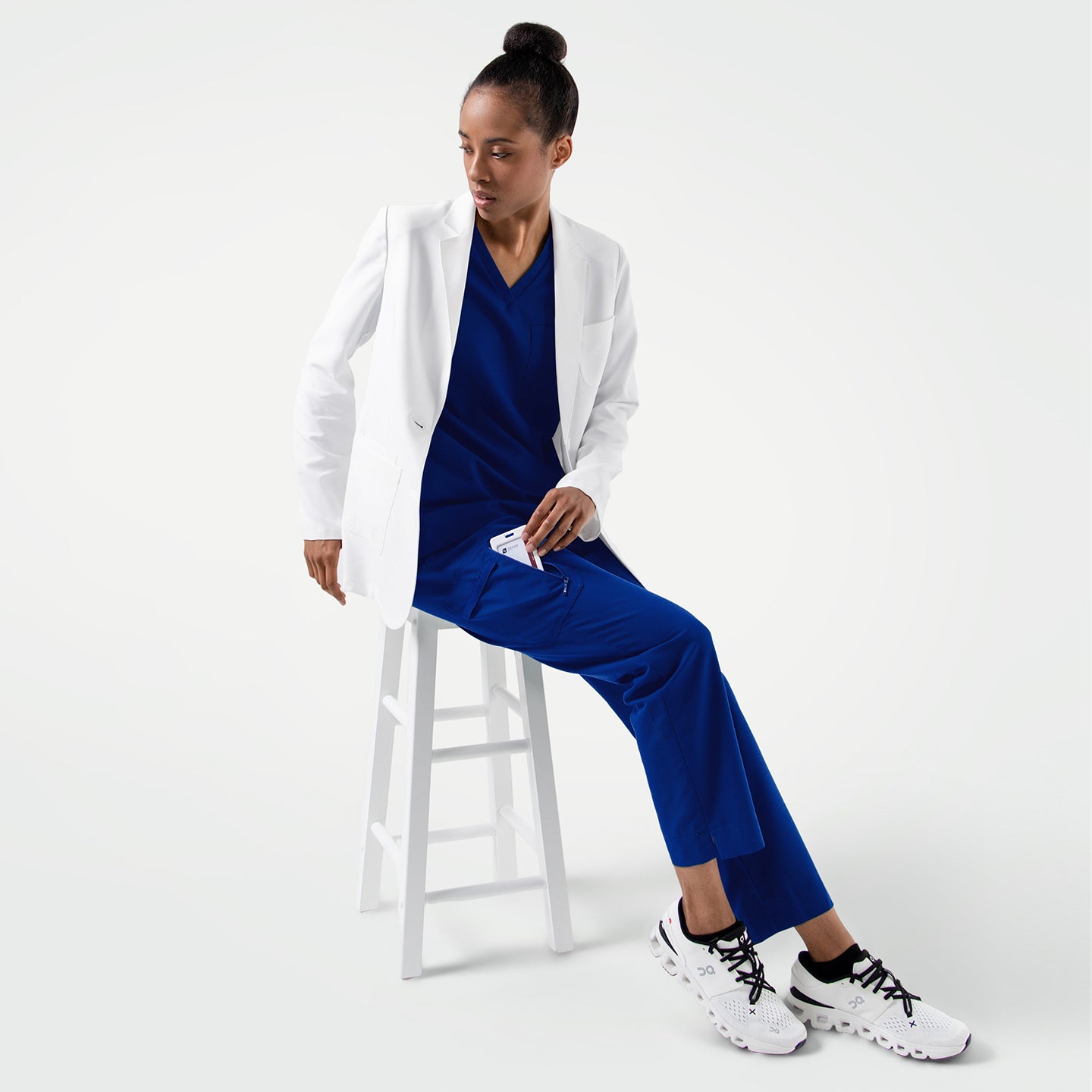 Image of The LCW-201 lab coat pairs a sleek, modern silhouette with a bright white finish, offering a sharp professional look layered effortlessly over vibrant scrubs while maintaining comfort, structure, and mobility for everyday clinical wear.