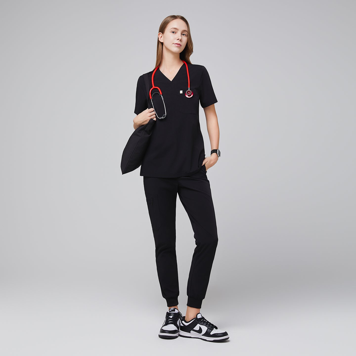 Image of Medical professional wearing jogger-style scrub pants with a stethoscope and carrying a bag,Midnight Black