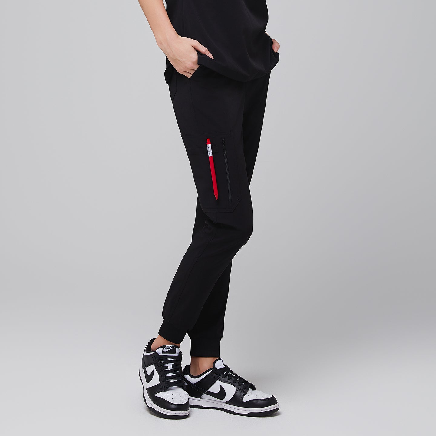 Image of Jogger-style scrub pants with a zippered side pocket and sneakers worn by a medical professional,Midnight Black