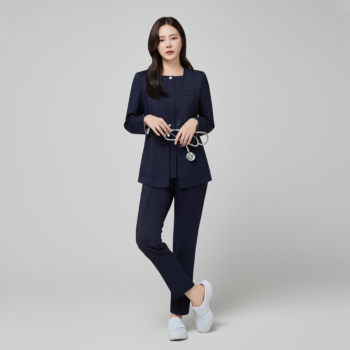 Full-length shot of a model wearing the TUL NS-172 Women's Modern Square Collar Scrub Top in Mir Navy, paired with matching pants for a cohesive professional look.