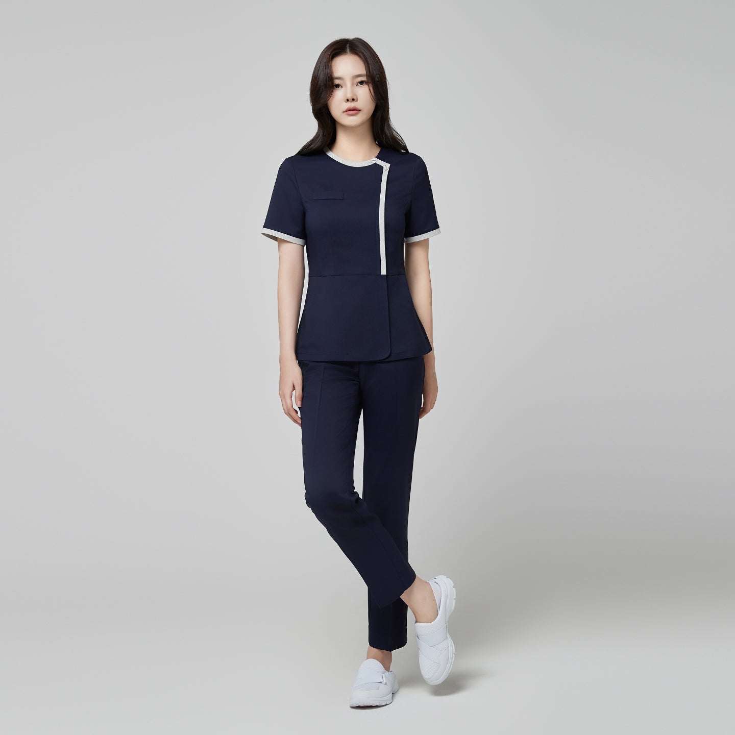 Image of Model wearing TUL NS-174 Mir Navy scrub top with a check gray round collar, showcasing a modern, polished fit and coordinating navy pants.