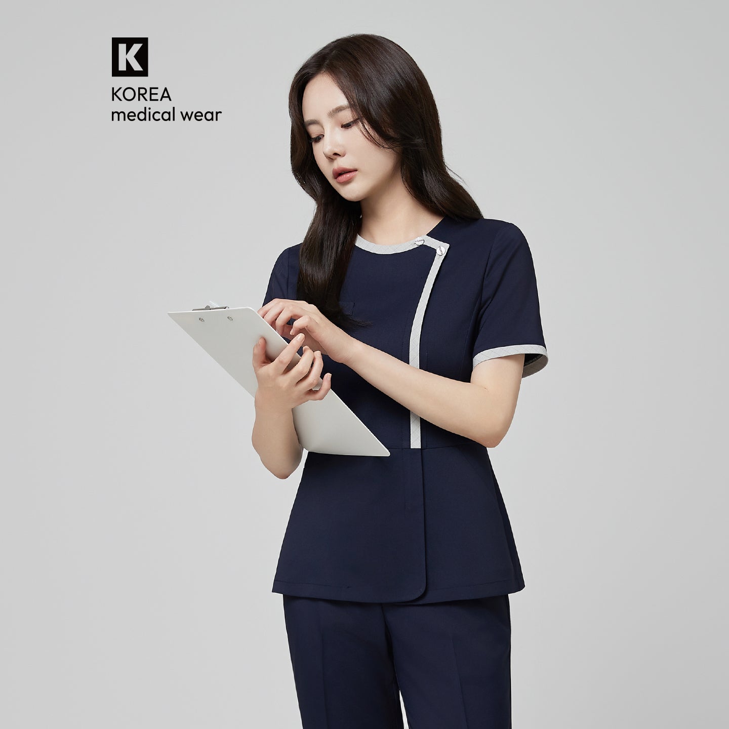 Image of Model wearing TUL NS-174 Women’s Check Gray Round Collar Scrub Top in Mir Navy, featuring a contrasting gray trim around the neckline and front.