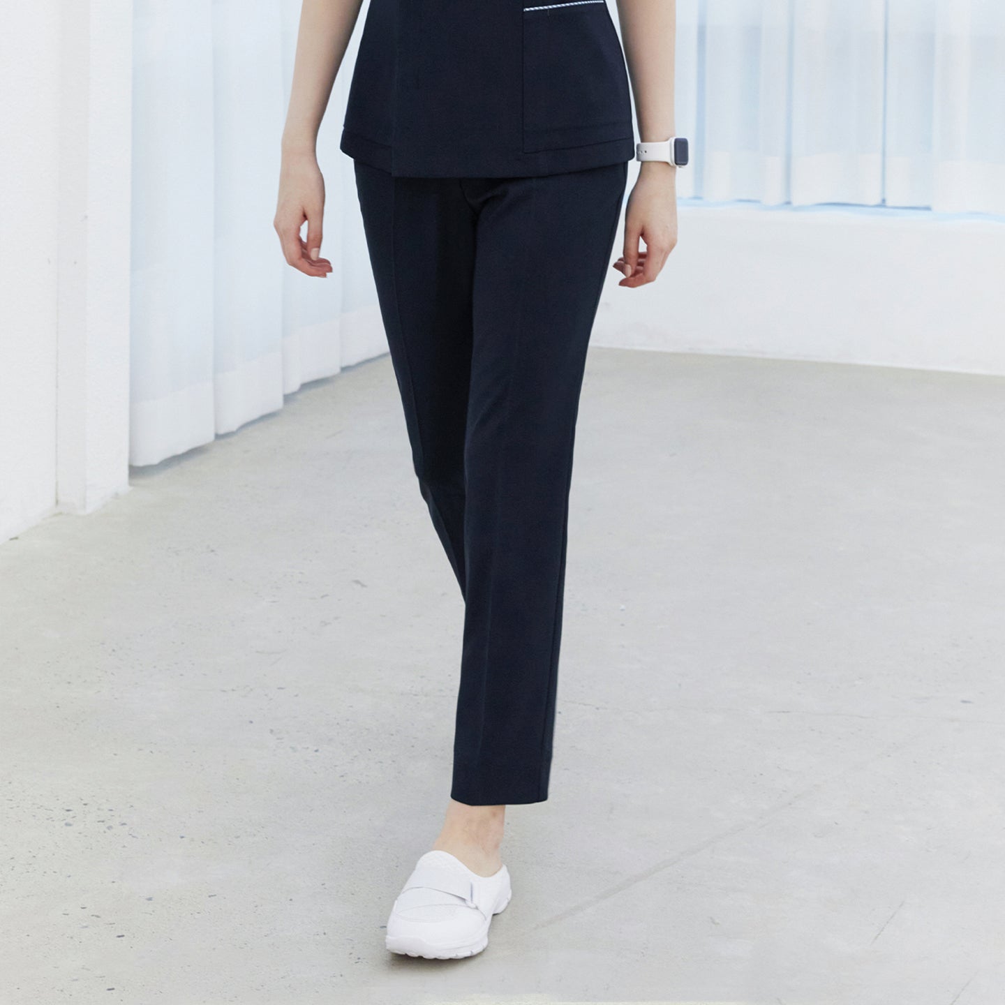 Image of Woman wearing navy side-banding scrub pants paired with a matching top and white shoes,Mir Navy