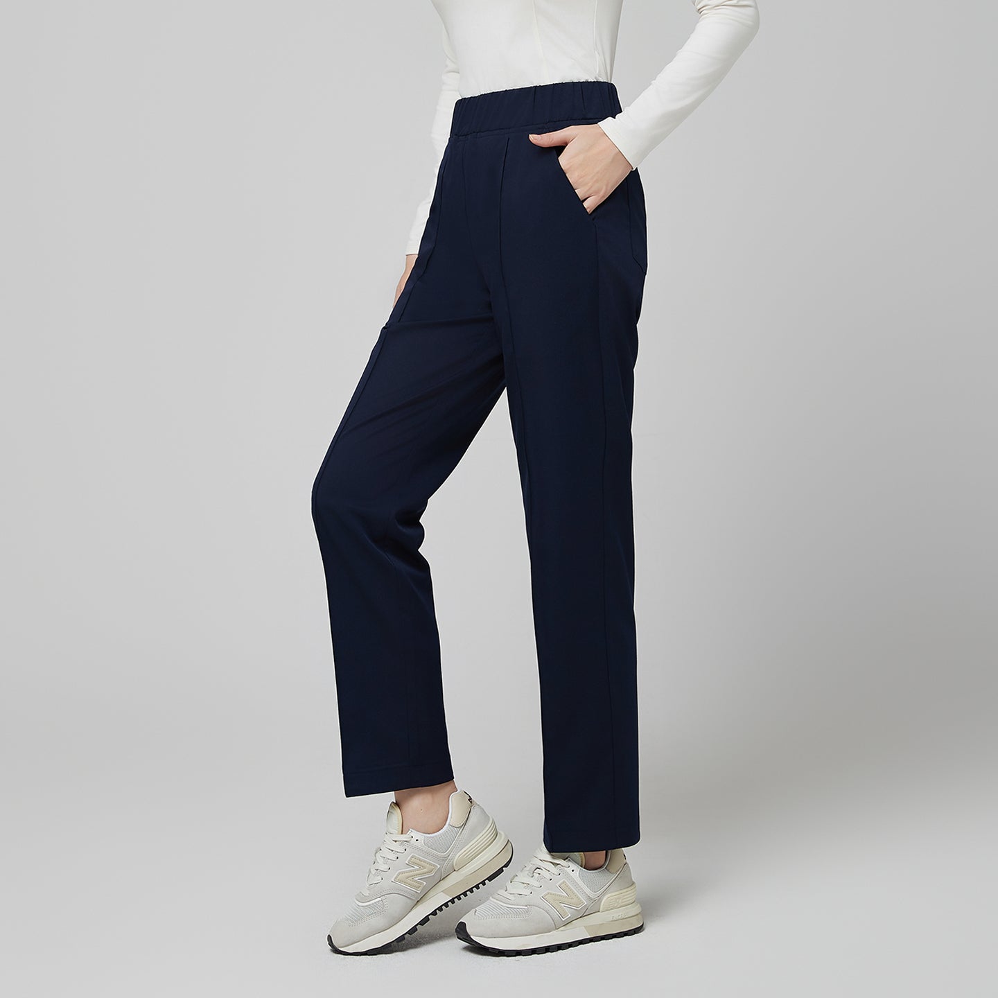 Image of Model wearing TUL Women's Premium Banding Pants in Mir Navy, paired with a matching scrub top for a cohesive, professional look.