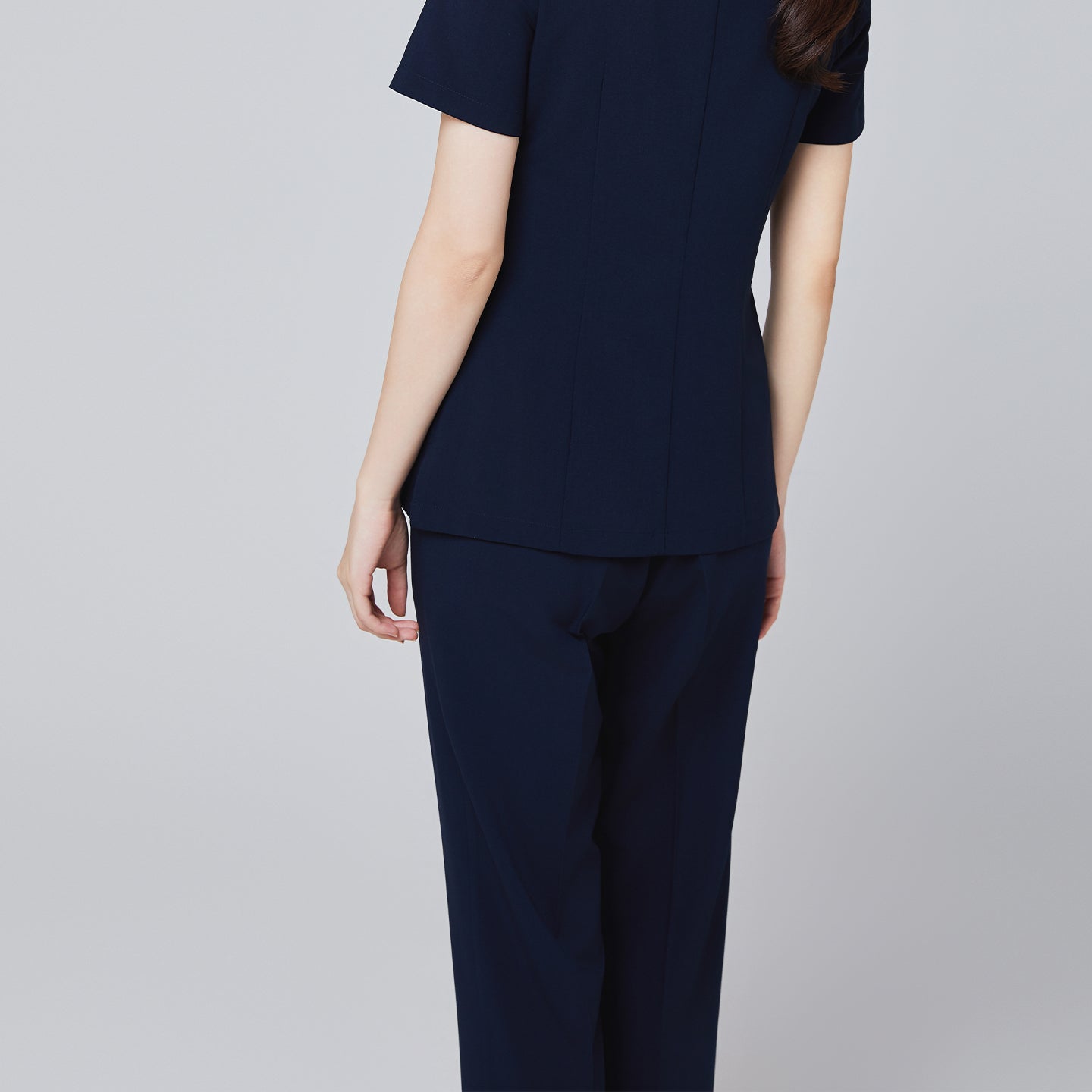 Image of Back of women's Pocket Banding Pants in Navy with matching scrub top and matching navy sneakers,Navy