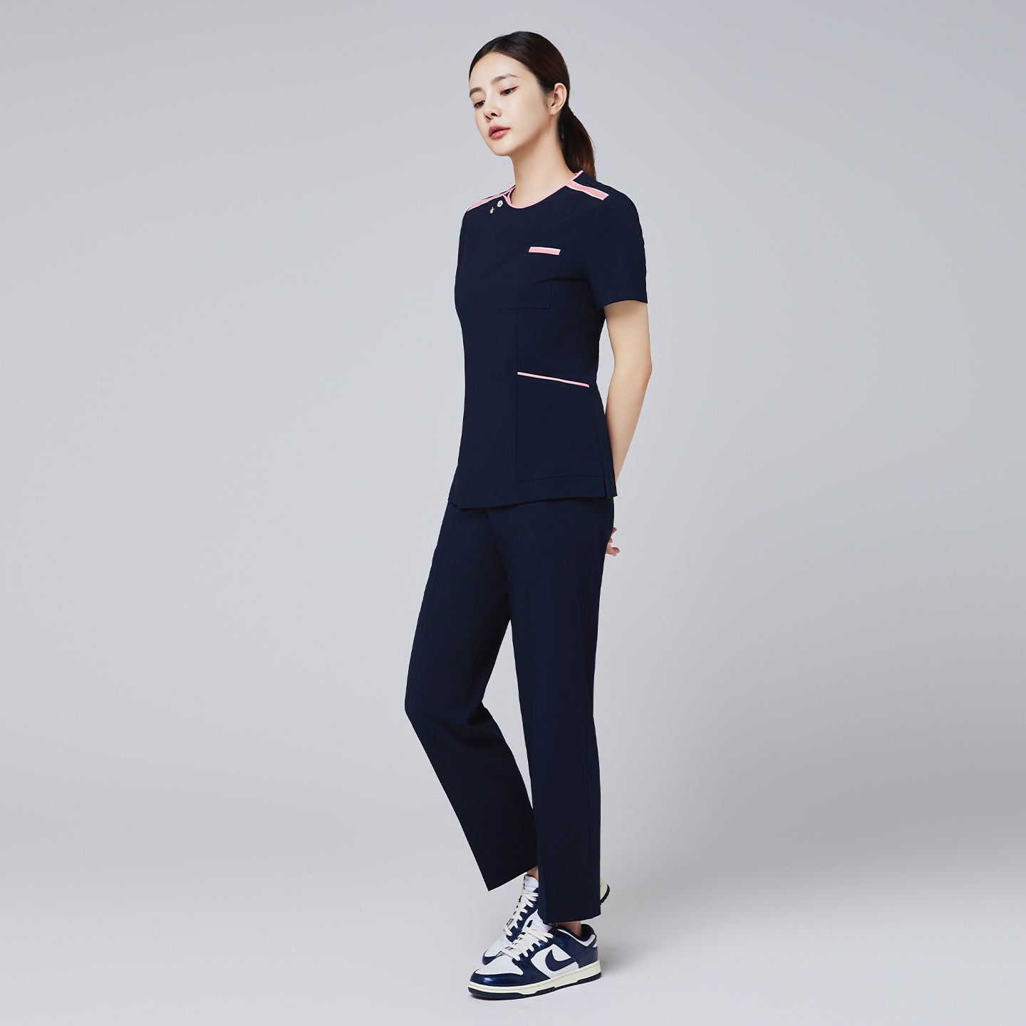 Image of Women's Pocket Banding Pants in Navy with matching scrub top and matching navy sneakers,Navy