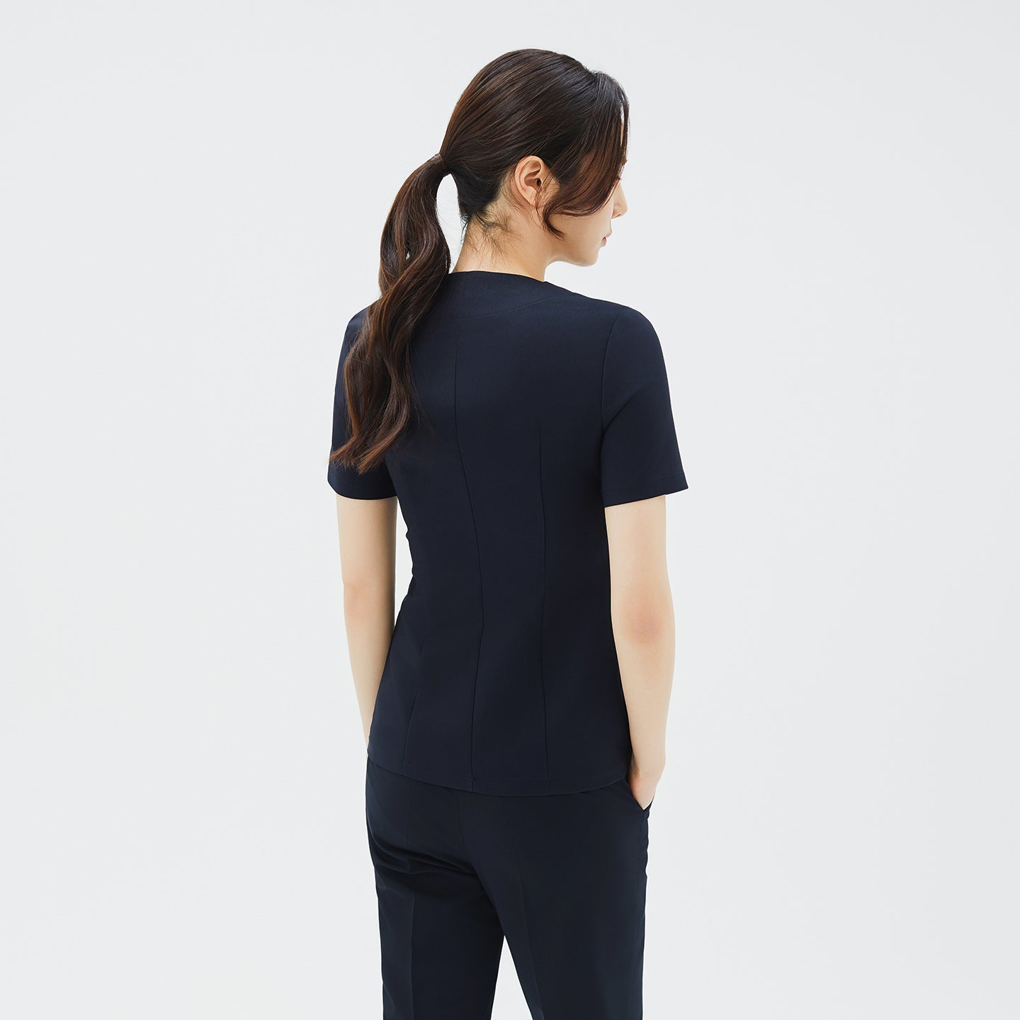 Image of Back view of the navy scrub top, showing its tailored seams and short-sleeve design,Navy
