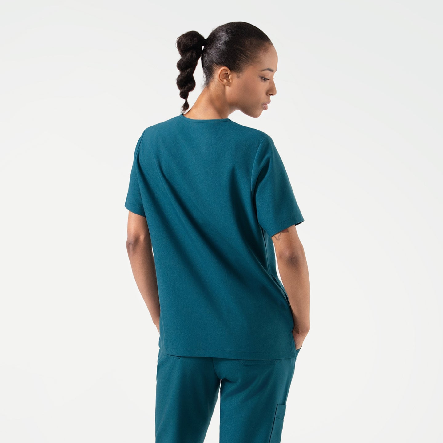 Image of The Ocean Teal Double Pocket Scrub Top presents a clean, structured back design with a relaxed fit that allows natural movement.