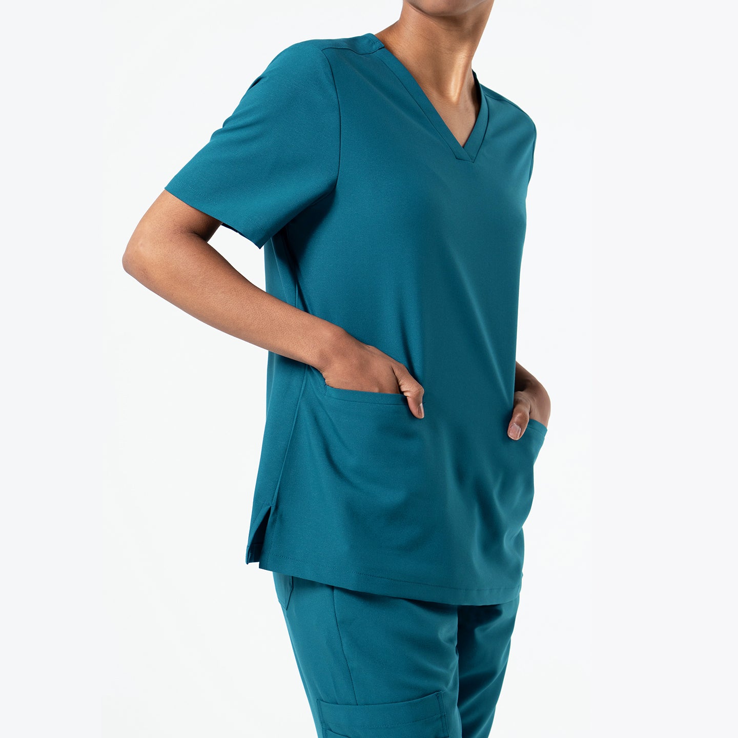 Ocean Teal double-pocket scrub top featuring a clean V-neckline, spacious front pockets, and a relaxed fit paired with matching scrub pants.
