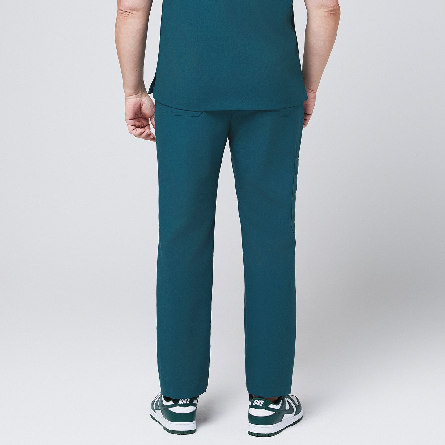 Image of Back of ocean teal straight scrub pants with side pockets and matching ocean teal scrub top, with teal sneakers,Ocean teal