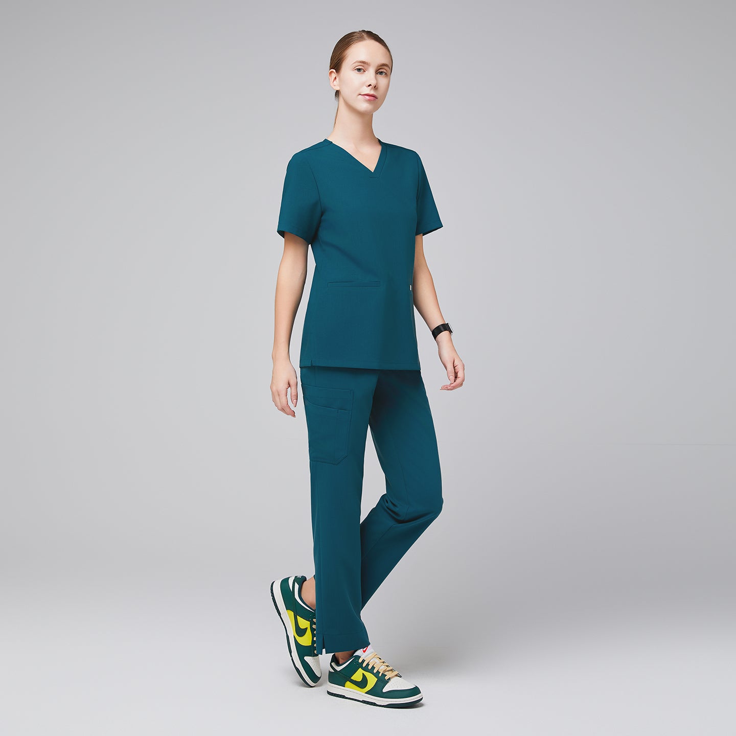 Image of Ocean teal scrub top and ocean teal straight scrub pants with a split hem, with green sneakers,Ocean teal