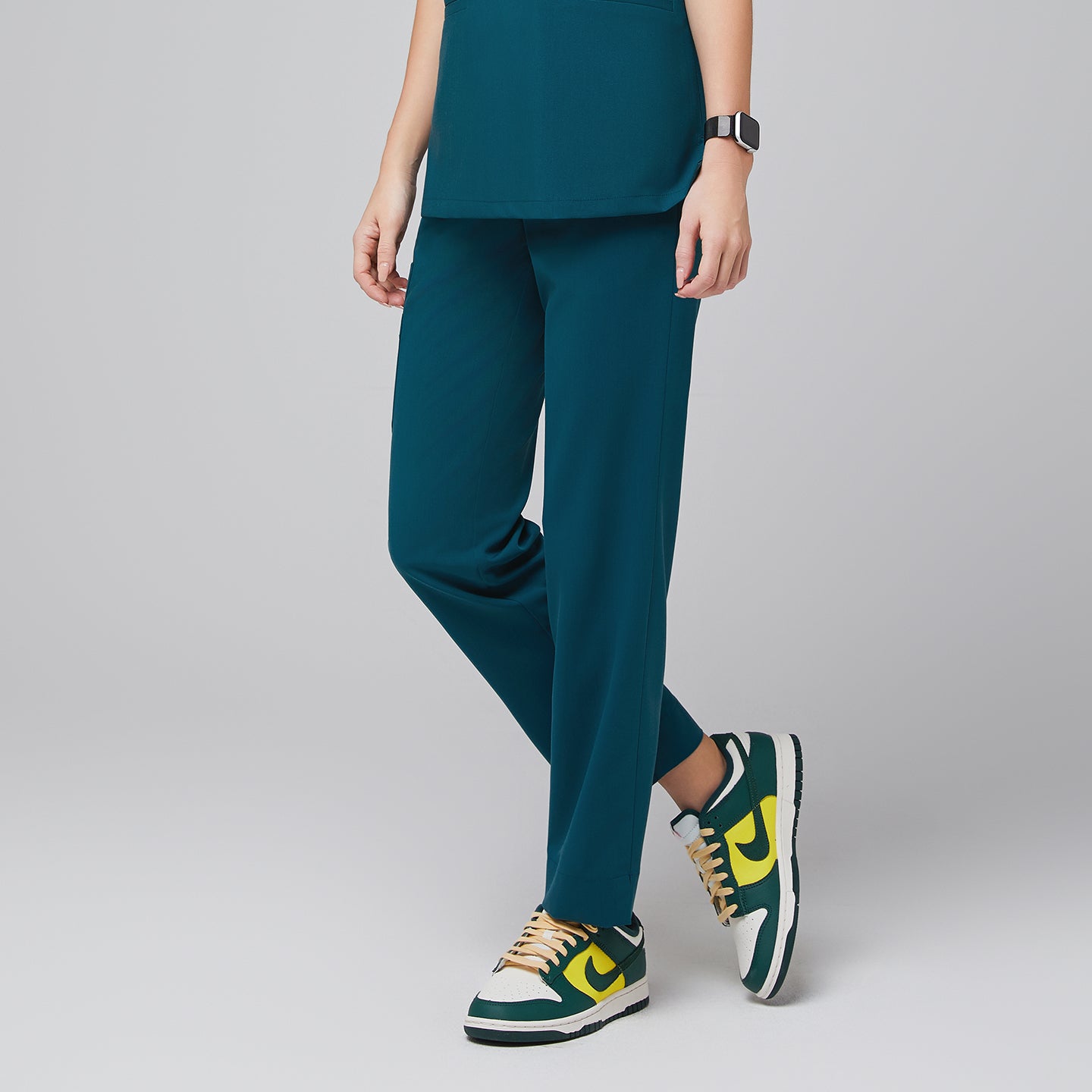 Image of Ocean teal scrub top and ocean teal straight scrub pants with a split hem, with green sneakers,Ocean teal