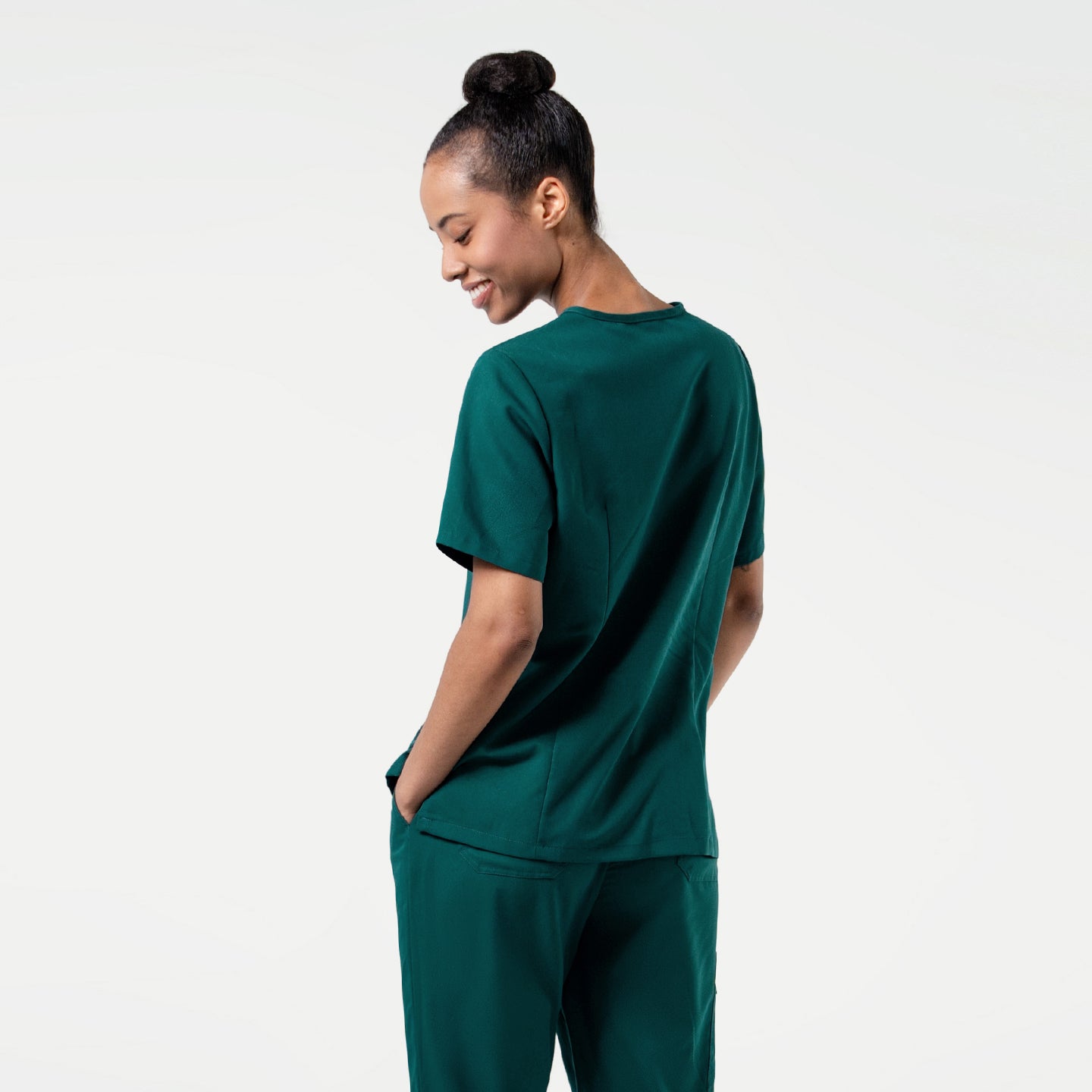Image of The Pine Green 3 Pocket Scrub Top features a deep forest green color with a smooth, tailored fit that complements professional movement.