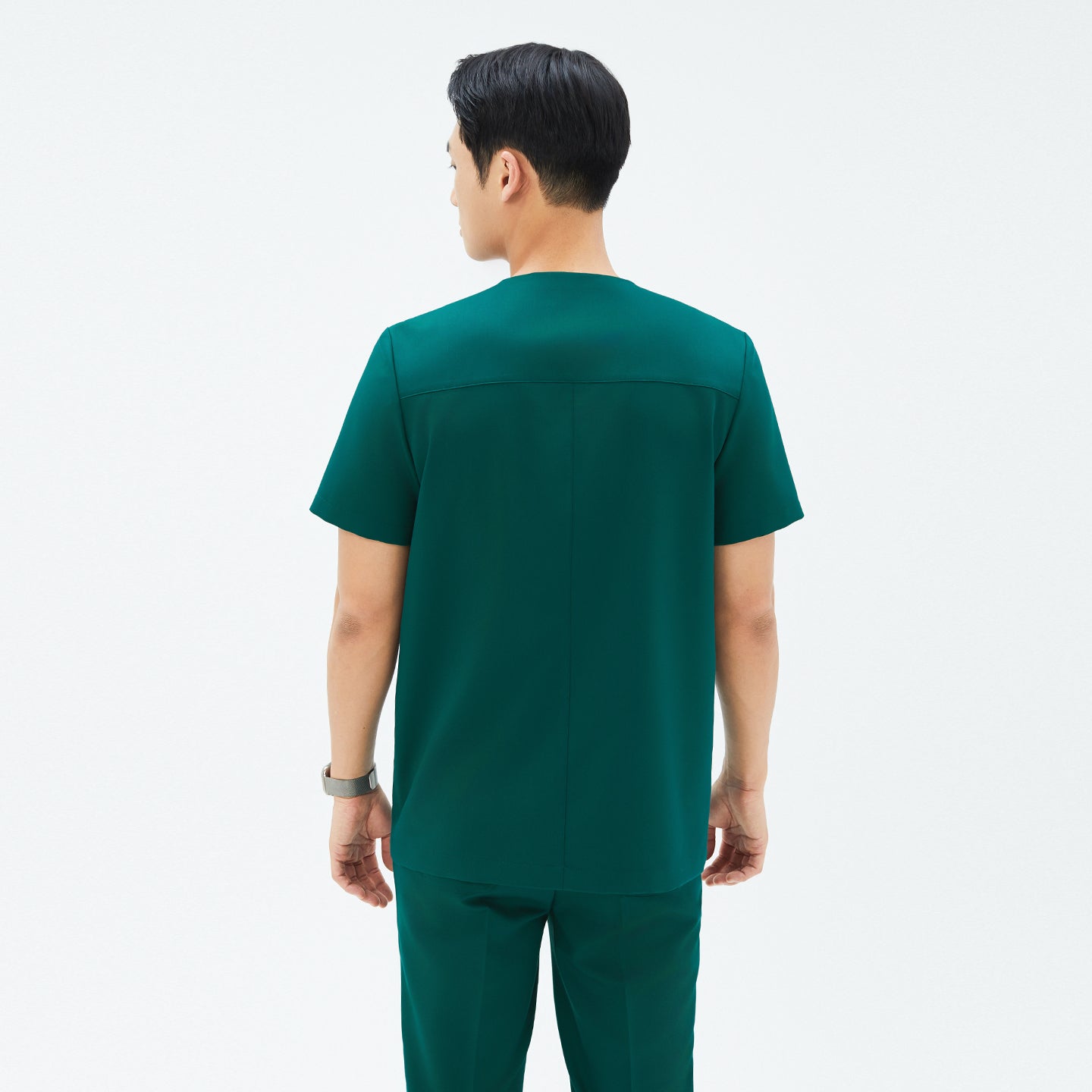 Back view of TUL DS-191 Men's Pine Green scrub top, emphasizing structured seams and a comfortable short-sleeve design.